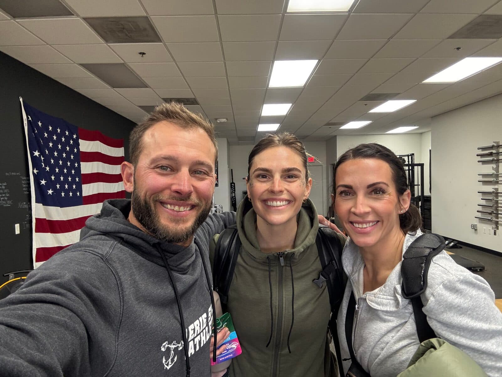 Coach Terry with two Erie Shore members smiling in the gym