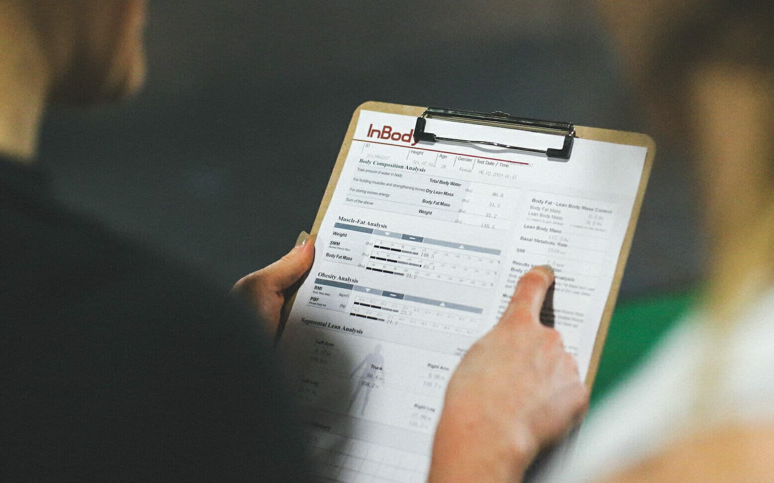 A coach reviewing body scan results on a clipboard